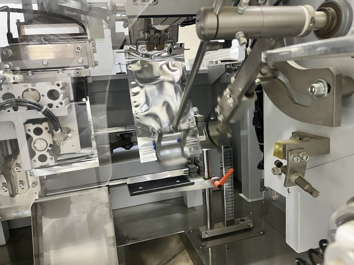 製造機で、柿茶を銀色の袋に詰めている工程