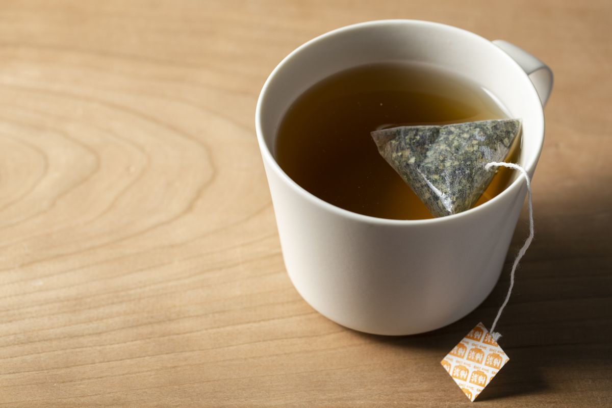 白いマグカップに入った柿茶とティーバッグ